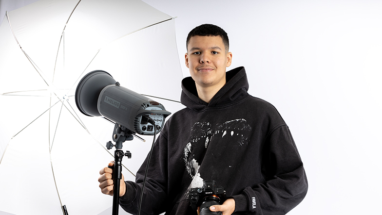 Anas im Fotostudio mit Kamera und Reflexschirm.